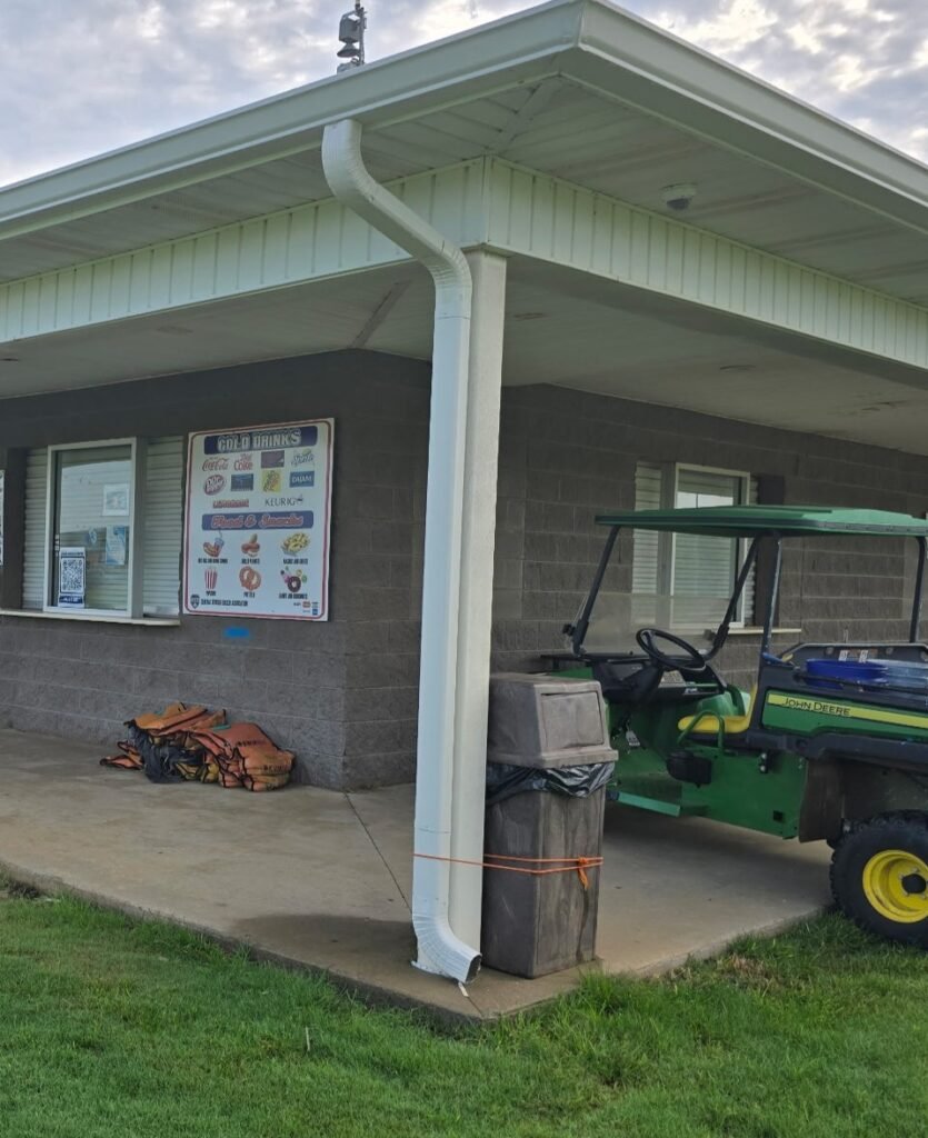 Commercial building with white downspout and gutter system installed to improve drainage and protect the exterior from heavy Georgia rainfall.